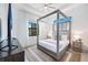 Main bedroom with a four-poster bed, TV and a large window at 14219 Wenzel Ave, Port Charlotte, FL 33981
