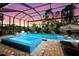 Expansive pool and spa surrounded by lush landscaping under a covered patio at 14219 Wenzel Ave, Port Charlotte, FL 33981