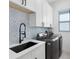 Laundry room with blue and white patterned backsplash and modern appliances at 14219 Wenzel Ave, Port Charlotte, FL 33981