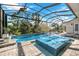 Relaxing pool and spa with a covered patio and lush landscaping at 14219 Wenzel Ave, Port Charlotte, FL 33981