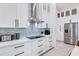 White kitchen with blue patterned backsplash and stainless steel appliances at 14219 Wenzel Ave, Port Charlotte, FL 33981