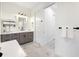 Modern bathroom with gray cabinets, white quartz countertop, and a soaking tub at 14219 Wenzel Ave, Port Charlotte, FL 33981