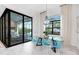 Bright dining area with glass table and blue chairs, looking out to a covered patio at 14219 Wenzel Ave, Port Charlotte, FL 33981