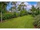 Large backyard with lush landscaping and expansive grassy area at 8175 Dittmar St, Port Charlotte, FL 33981