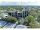An aerial view showcasing a multi-story residential building, pool, and lush landscaping at 512 W Venice Ave # 403, Venice, FL 34285