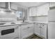 White kitchen with stainless steel appliances and shaker cabinets at 1522 Pleasant Rd # G23, Bradenton, FL 34207