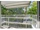 White railing balcony overlooks lush green trees and a neighborhood street at 1522 Pleasant Rd # G23, Bradenton, FL 34207