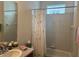 Cozy bathroom featuring a shower-tub combo with a floral curtain and a round mirror at 7818 33Rd E St, Sarasota, FL 34243