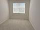 A bedroom with neutral carpet, a large window with blinds, and ample natural light at 7818 33Rd E St, Sarasota, FL 34243