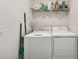 Well-equipped laundry room with washer, dryer, and storage shelves at 850 Tidewater Shores Loop # 102, Bradenton, FL 34208