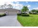 Tan one-story home with two-car garage and manicured lawn at 5092 Mahogany Run Ave, Sarasota, FL 34241