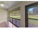 Screened porch with view of trees and golf course at 4573 Kingsmere # 27, Sarasota, FL 34235
