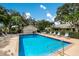 Community pool with lounge chairs and lush landscaping at 4573 Kingsmere # 27, Sarasota, FL 34235