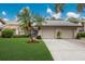 Two-car garage and front entry of condo with palm trees at 4573 Kingsmere # 27, Sarasota, FL 34235