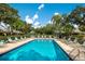 Inviting community pool surrounded by tropical landscaping at 4573 Kingsmere # 27, Sarasota, FL 34235