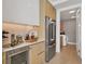 Modern kitchen with wine cooler, stainless steel appliances and light wood cabinets at 301 Quay Commons # 1209, Sarasota, FL 34236