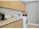 Modern laundry room with washer, dryer, and built-in cabinetry at 301 Quay Commons # 1209, Sarasota, FL 34236