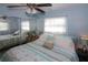 King-size bed with coastal bedding, mirrored closet doors and ceiling fan in a light-blue bedroom at 22119 Laramore Ave, Port Charlotte, FL 33952