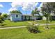 Charming light blue home with a covered porch and manicured lawn at 22119 Laramore Ave, Port Charlotte, FL 33952