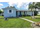 Charming light blue home with a covered porch and manicured lawn at 22119 Laramore Ave, Port Charlotte, FL 33952