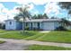 Ranch-style home with a spacious lawn and palm trees at 22119 Laramore Ave, Port Charlotte, FL 33952