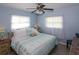 King-size bed with coastal bedding, ceiling fan, and light-blue walls in a well-lit bedroom at 22119 Laramore Ave, Port Charlotte, FL 33952