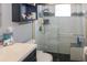 Bathroom with a walk-in shower, white tile, and dark vanity at 22119 Laramore Ave, Port Charlotte, FL 33952