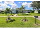 Light blue house with a green lawn and two palm trees in front at 22119 Laramore Ave, Port Charlotte, FL 33952