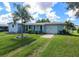 Cute light blue house with a large yard and palm trees at 22119 Laramore Ave, Port Charlotte, FL 33952