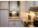 Modern kitchen features white cabinets, granite countertops, and stainless steel appliances at 22119 Laramore Ave, Port Charlotte, FL 33952