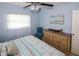 King-size bed with coastal bedding, dresser, and chair in a light-blue bedroom with ocean art at 22119 Laramore Ave, Port Charlotte, FL 33952