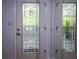 White front door with glass panels featuring a geometric design, offering natural light and curb appeal at 22119 Laramore Ave, Port Charlotte, FL 33952
