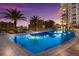 Relaxing nighttime pool view with palm trees and city skyline at 111 S Pineapple Ave # 1021, Sarasota, FL 34236