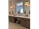 Modern bathroom featuring double sinks, quartz countertops, arched mirrors, and stylish globe pendant lighting at 11709 Capstan Pl, Parrish, FL 34219