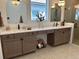 Bathroom featuring double vanity, quartz countertops, modern mirrors, and a glass door shower at 11709 Capstan Pl, Parrish, FL 34219