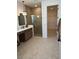 Primary bathroom with double vanity, modern mirrors, enclosed shower, and a walk-in closet at 11709 Capstan Pl, Parrish, FL 34219