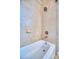 Close-up of a bathtub with a tile surround and a shower featuring a rainfall showerhead at 5120 Tidewater Preserve Blvd, Bradenton, FL 34208