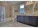 Well-lit bathroom with a tub and shower combination, featuring a wide vanity and tiled floor at 5120 Tidewater Preserve Blvd, Bradenton, FL 34208