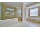 Elegant bathroom showcasing a glass-enclosed shower and soaking tub near a window for natural light at 5120 Tidewater Preserve Blvd, Bradenton, FL 34208