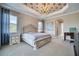 Spacious bedroom with decorative tray ceiling, chandelier, and a large window for natural light at 5120 Tidewater Preserve Blvd, Bradenton, FL 34208