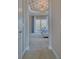 View through the doorway towards the bedroom which features a tray ceiling, chandelier, and outdoor patio at 5120 Tidewater Preserve Blvd, Bradenton, FL 34208