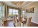 Dining area featuring a wood table, six upholstered chairs, a chandelier, and natural light from large windows at 5120 Tidewater Preserve Blvd, Bradenton, FL 34208