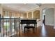 Elegant foyer featuring a grand piano, hardwood floors, arched doorway, and ornate chandelier and wall art at 5120 Tidewater Preserve Blvd, Bradenton, FL 34208