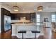 Open kitchen with a granite island, pendant lighting, stainless steel appliances, and dark wood cabinetry at 5120 Tidewater Preserve Blvd, Bradenton, FL 34208