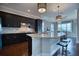 Stylish kitchen island features granite countertops, pendant lights, and dark cabinetry, adjacent to a dining area at 5120 Tidewater Preserve Blvd, Bradenton, FL 34208