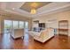 Cozy living room with hardwood floors, tray ceiling, and a serene view from sliding glass doors at 5120 Tidewater Preserve Blvd, Bradenton, FL 34208