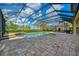 Backyard oasis with a screened-in pool, a spa, and a basketball court, complemented by lush palm trees at 5120 Tidewater Preserve Blvd, Bradenton, FL 34208