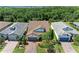 An aerial view of houses with well-maintained lawns, mature trees, and brick driveways at 7572 Viola Loop, Lakewood Ranch, FL 34202