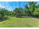 Spacious backyard features lush lawn, mature trees, and a secure black metal fence at 7572 Viola Loop, Lakewood Ranch, FL 34202