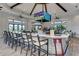 Stylish bar area with counter seating, TVs, and an open layout for socializing and entertainment at 7572 Viola Loop, Lakewood Ranch, FL 34202